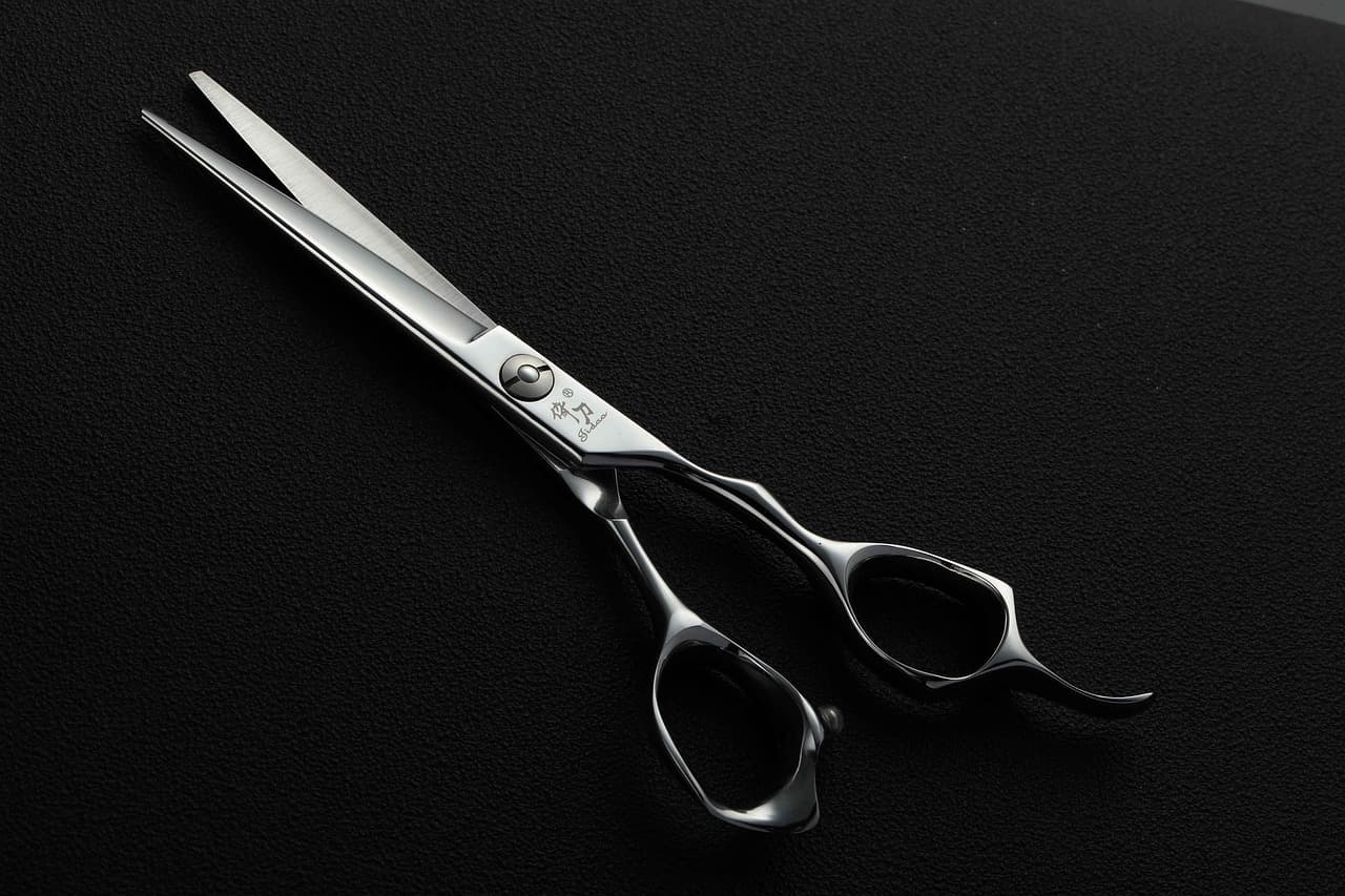 A pair of barber's scissors on black