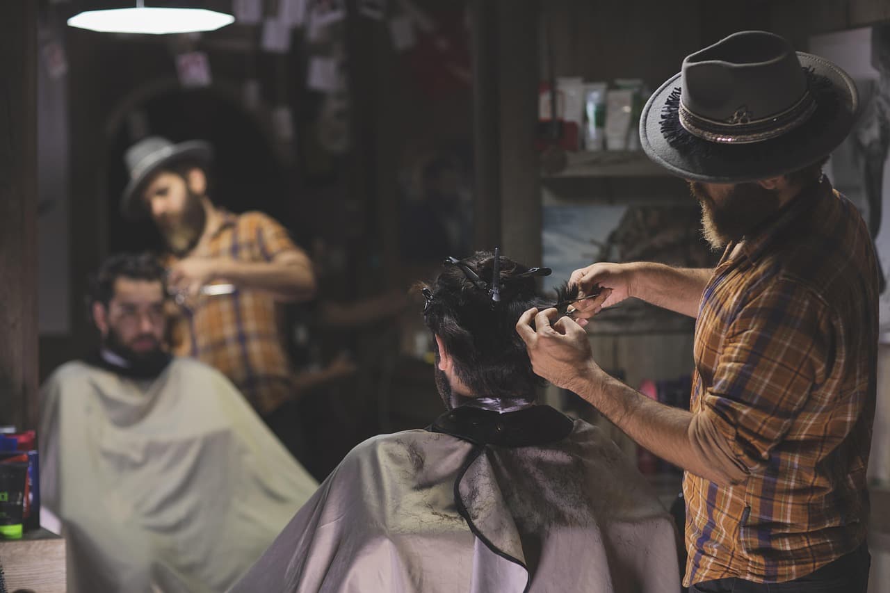 Barbers at work on a busy afternoon, clients in capes